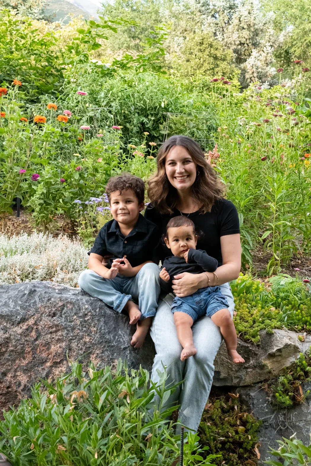Dr. Samantha Montoya sitting in a flower garden with her sons Jaden and Noah